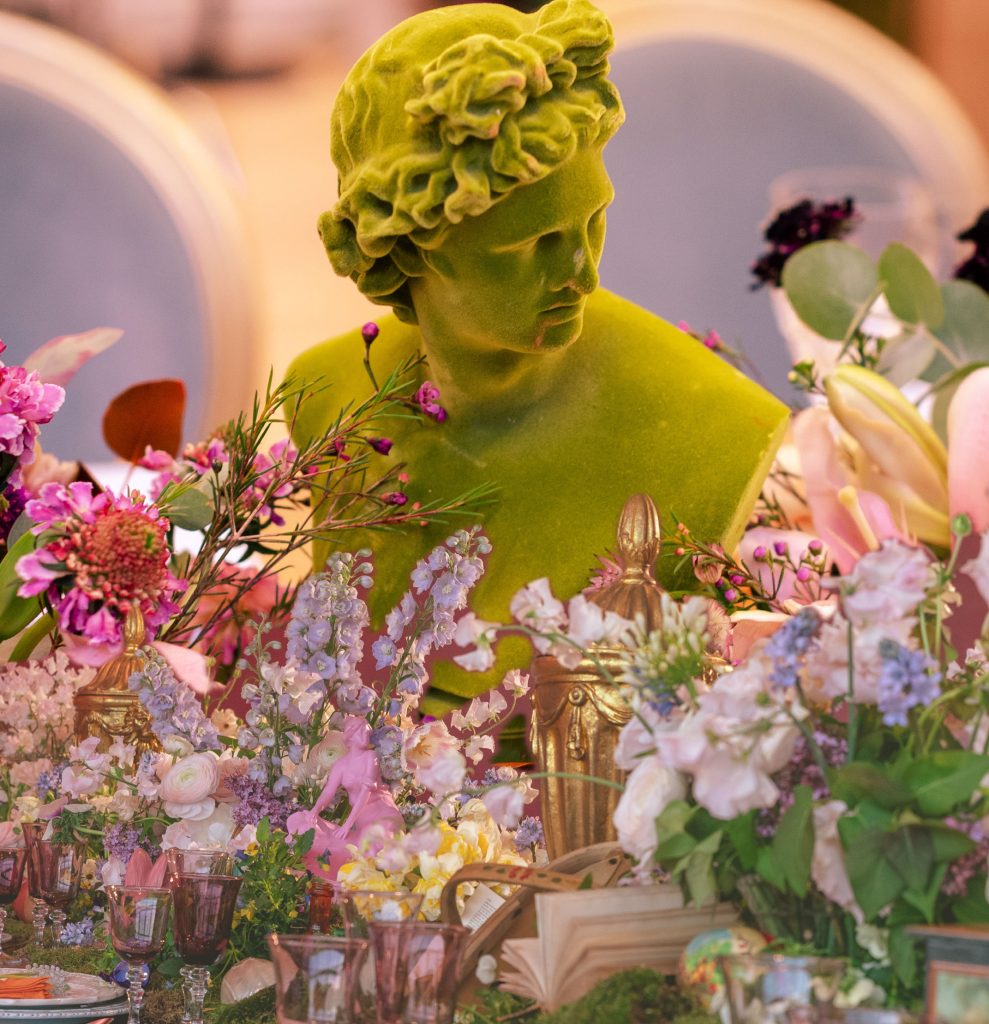 Meadow flowers in various colours and a green flocked statue of Apollo.