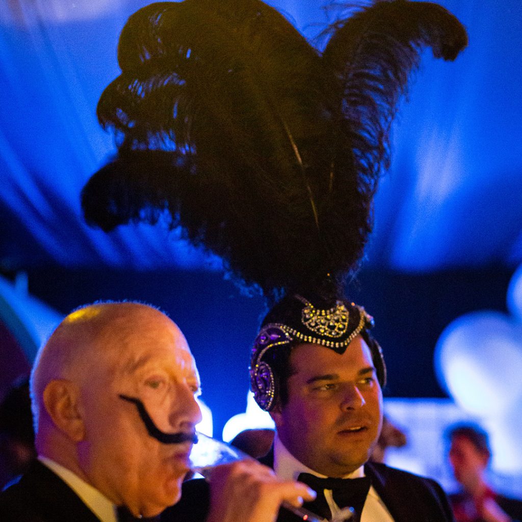 A man wearing a black feathered surrealist hat.