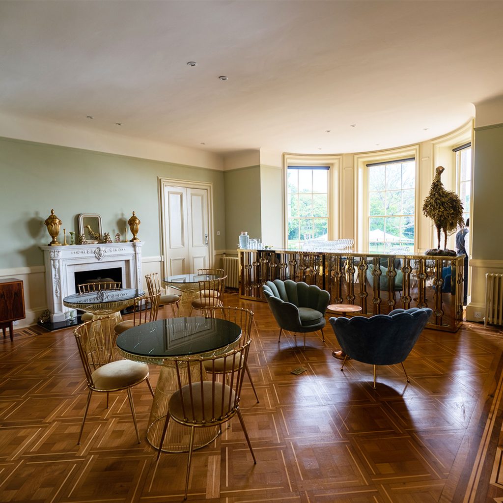 A room filled with furniture and a gold bar with a golden peacock.