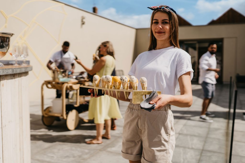 A woman holding an usherette tray of ice creams and cones.