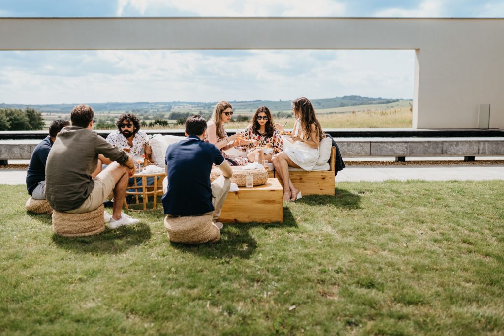 Group of people sitting together on a lawn.