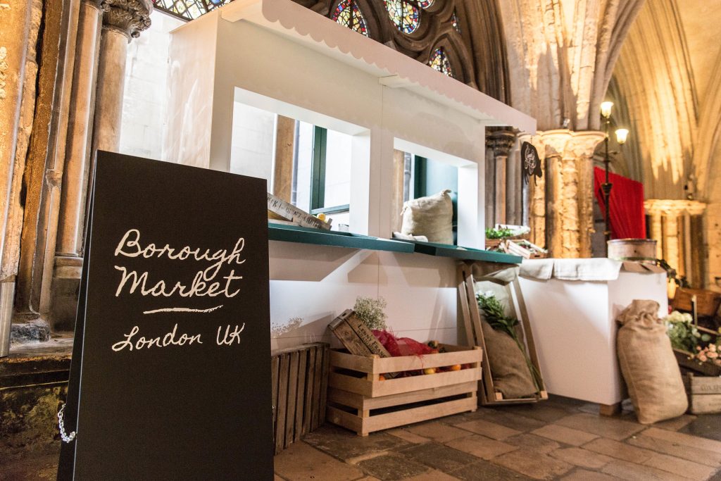 A wooden white structure with a black A-Frame and various props on the theme of Borough Market