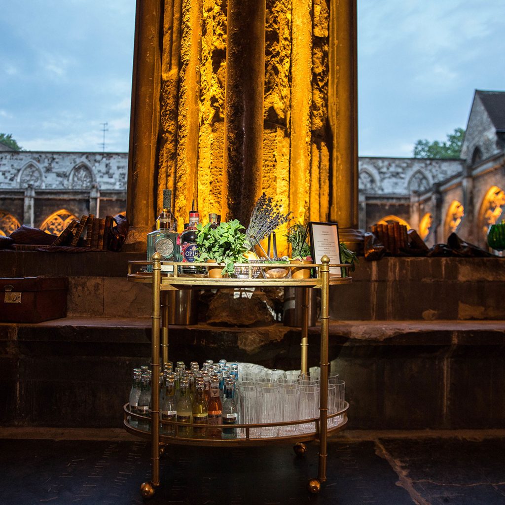 Cocktail trolly with different spirits, garnishes and glassware.