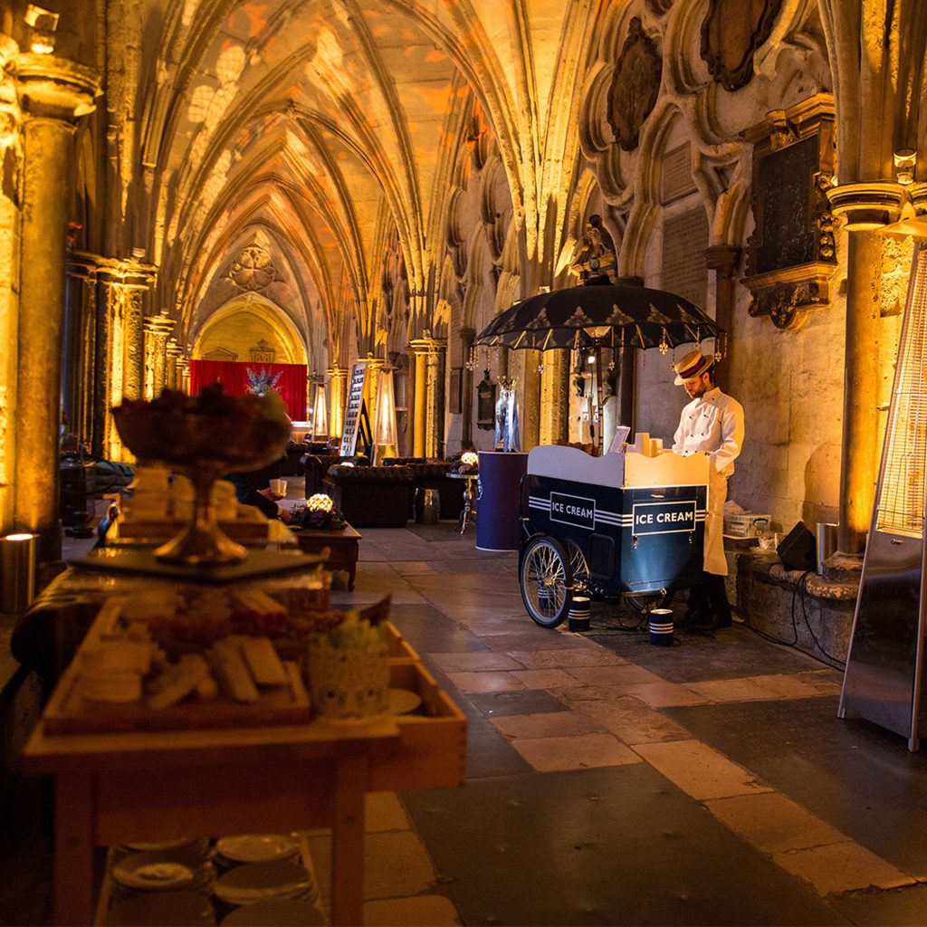The Cloister of Westminster Abbey with furniture, an ice cream vendor and event lighting set for a private event.