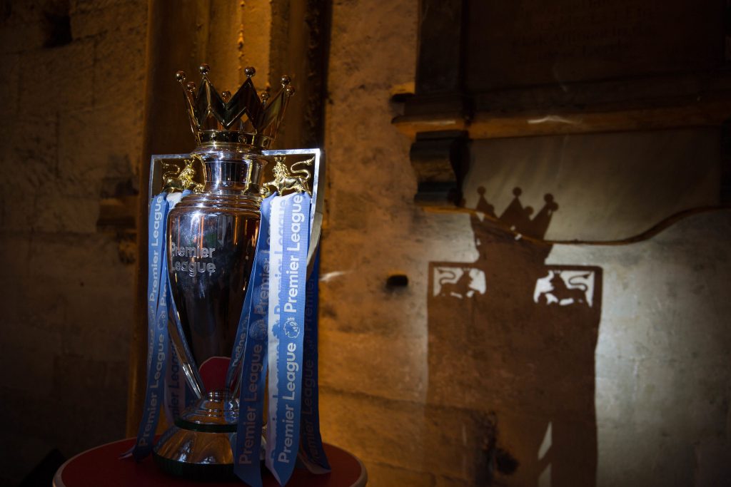 Premier League trophy lit casting a shadow on a wall. Brand event planner.