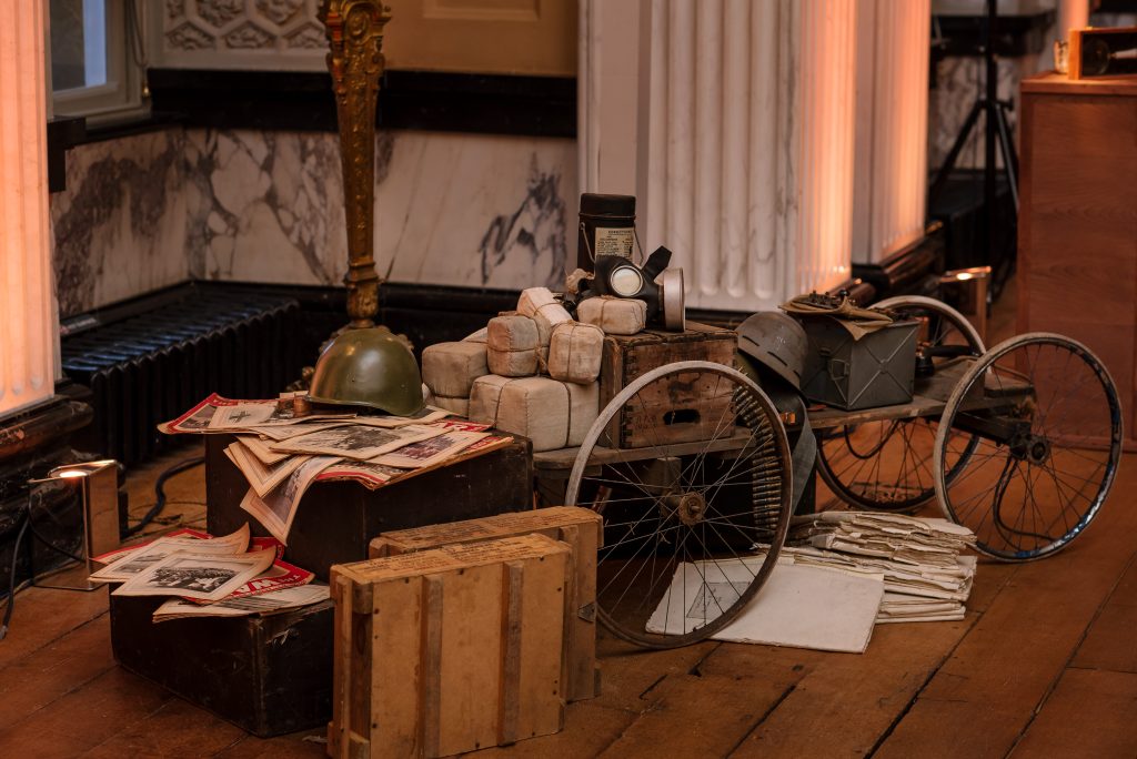A cart full of war memorabilia and war helmets.