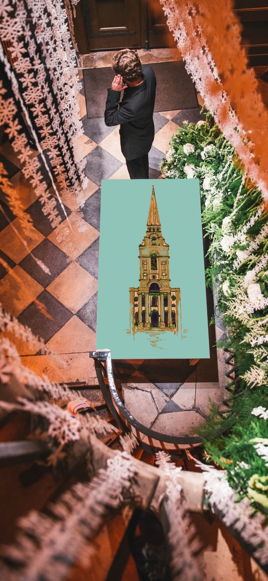 A stairwell covered in Christmas wreaths and snowflakes and an illustration of a church.