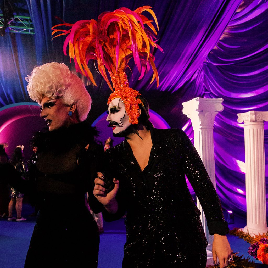 Two drag performers one with an orange wig.